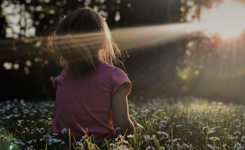 Girl in sunshine and field of daisies discovering her identity in Christ