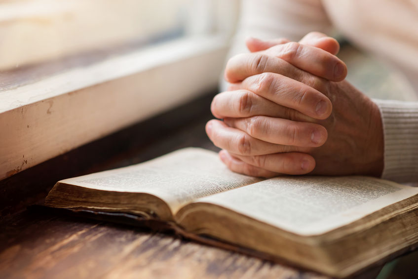 picture of praying hands with Bible, digging deeper into the Bible