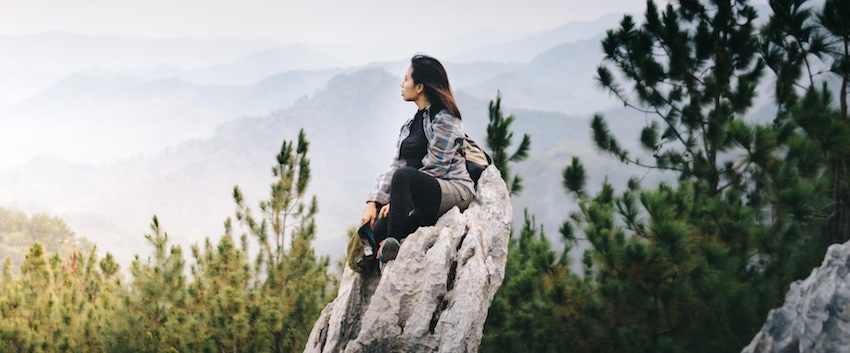 woman sitting on rock looking at mountains, in the presence of God
