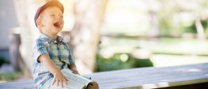 boy with Bible laughing on bench, to obey God