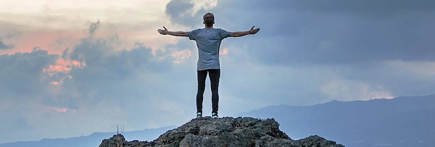 man on mountain, facing challenges head-on