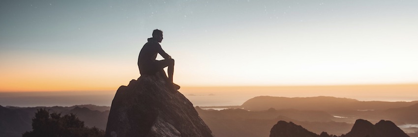 man sitting on mountain top, spiritual identity